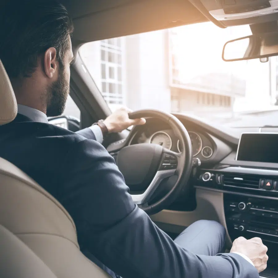 Homme en costume conduisant une voiture