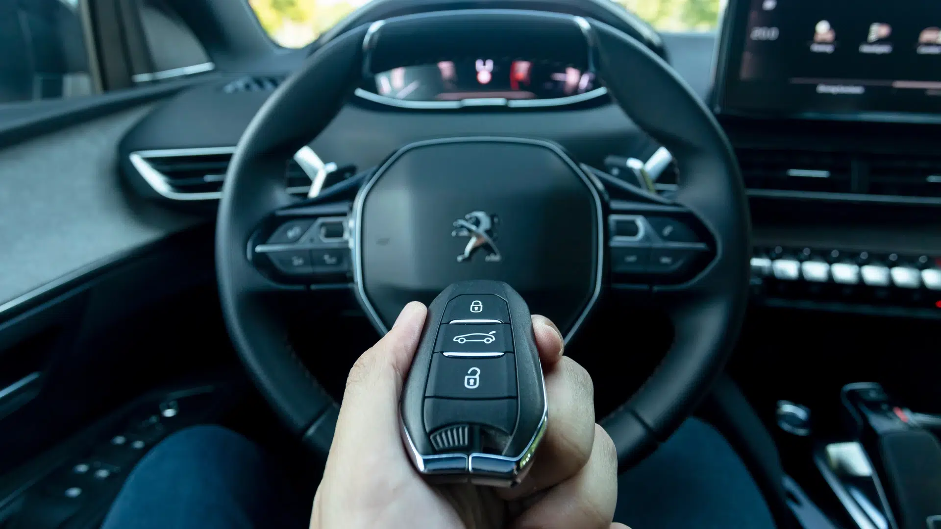 Clé de voiture Peugeot devant volant